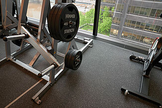 A weightlifting area in a fitness center, featuring a rack of weights and a large glass wall.