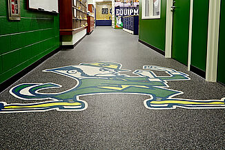 Close-up of the Notre Dame logo inlaid in the Gray Ghost REGUPOL aktiv flooring.