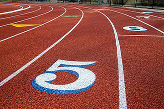 The number "5" is painted in white on St. John's REGUPOL champion AG running track, marking a specific lane.