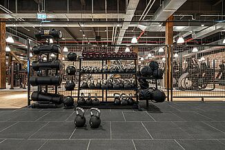 Racks with weights stand on a REGUPOL sports floor in the Gold's Gym fitness centre in Jena.