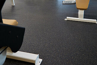 View of the REGUPOL aktiv rolled rubber flooring located in the New York Fitness in Lebanon. Gym equipment rests atop the durable, seamless flooring.