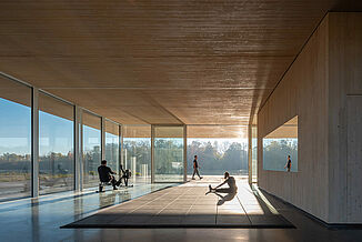 Inside view of the Neil Campbell Rowing Centre. The facility features REGUPOL aktivpro rubber tiles within the facility, with a view of the water through the glass walls.