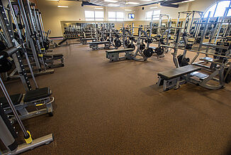 The free weight section of Team 85 features a variety of bench pressing machines and squat racks for members.