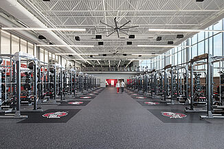 Ohio State University weight room with squat racks and weight benches, featuring the university's logo on a REGUPOL aktivpro roll in Thunder Gray, shock-absorbing floor.