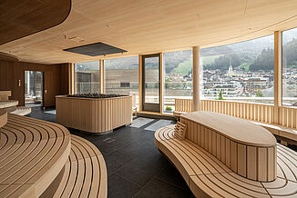 Modern sauna world with a large glass front and a view of the mountains at the Silvretta Therme in Ischgl.