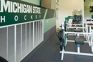 Michigan State University hockey weight room with black REGUPOL aktivpro roll flooring with lifting equipment.