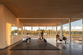 Inside view of the Neil Campbell Rowing Centre as various individuals work out on the REGUPOL aktivpro rubber tile flooring.