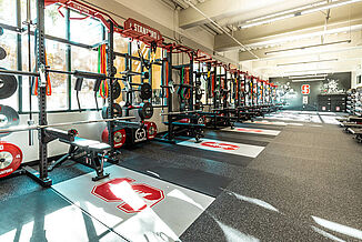 Rows of weight racks in Stanford University's athletic weight training facility, each featuring individual platforms allowing for increased durability REGUPOL crash platforms.