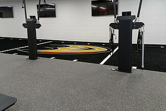 Multipurpose athletic weight training machines allow for a variety of athletic activities be performed in one area. The machines rest on REGUPOL aktivpro roll flooring and seamlessly transitions into the customized turf area.