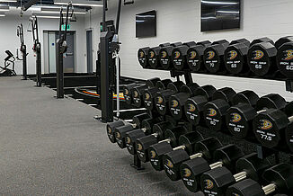 View of the dumbell rack and multipurpose cable machines in the Anaheim Ducks training facility. The equipment and racks are positioned on REGUPOL aktivpro roll flooring.