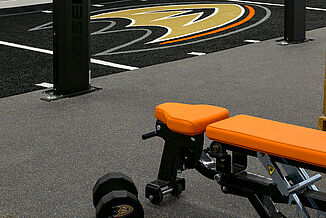 The Anaheim Duck's training facility features REGUPOL aktivpro roll flooring that seamlessly transitions into a turf area. The facility allows athletes to perform a variety of exercises, from weight training to cardio.