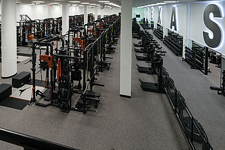 Expansive view of the University of Texas at Austin weight training facility. The facility offers a number of weight racks and platofrms, as well as free weights. REGUPOL aktipro roll flooring is used throughout the facility.