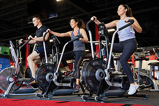 Athletes perform cardio exercises on cycling equipment in the UFC Gym. The equipment rests on REGUPOL aktiv flooring, providing a smooth surface for all equipment to set evenly upon.