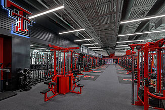 Far view of Texas Tech Olympic room, showcasing the machinery and cables that are offered to athletes. The variety of equipment allows athletes and trainers to conduct a number of specific exercises.