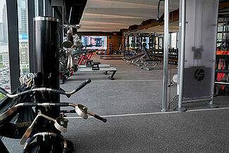 A spacious fitness center with a variety of weightlifting equipment, cardio machines, and open floor space.