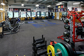 View of the weight racks and platforms featured at the Elite Training Systems facility located in the Iroquois Park Sports Centre. The REGUPOL aktivpro roll flooring seamlessly transitions with the inlaid REGUPOL crash platforms, providing a highly durable surface for athletes.